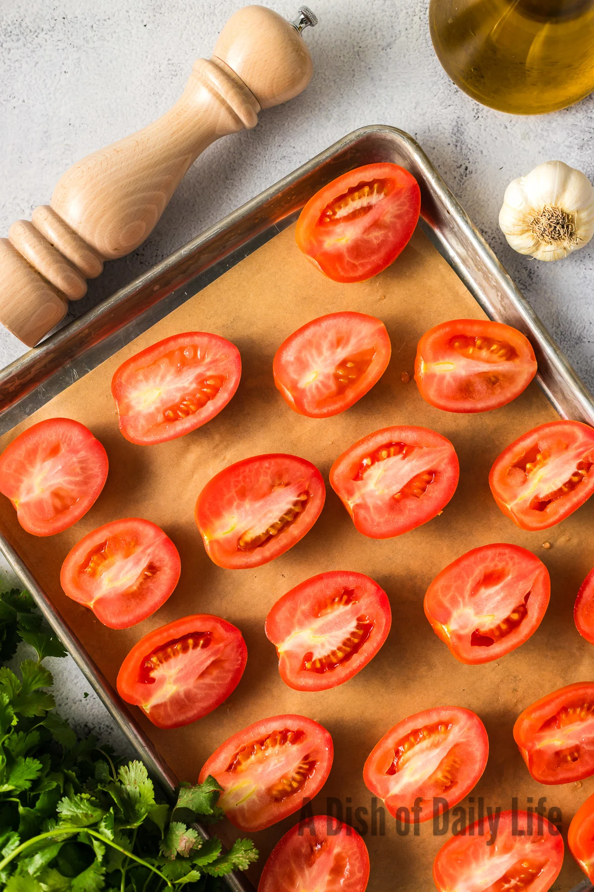 Roma tomatoes sliced in half on baking sheet