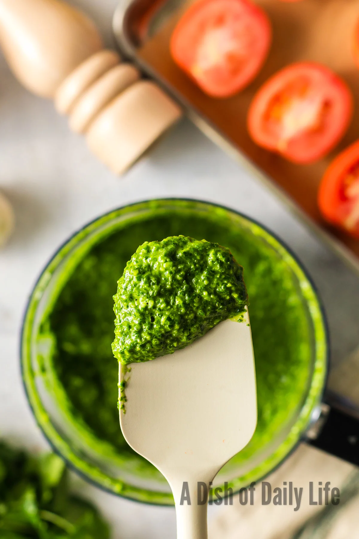 Cilantro paste being scooped out of food processor.