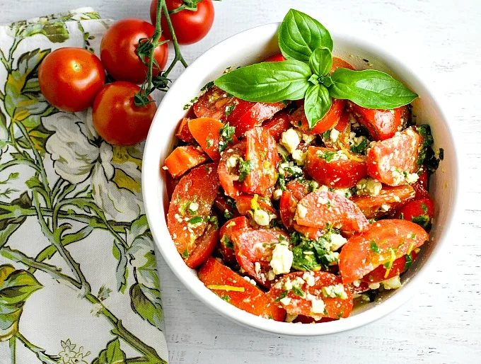 Colorful, healthy, and packed with flavor, this easy Tomato, Basil and Feta Summer Salad is the perfect side dish for any summer dinner, and even makes for a wonderful light lunch as well. Go ahead and customize it by adding in cucumber or even summer corn...the basil dressing goes well with everything!