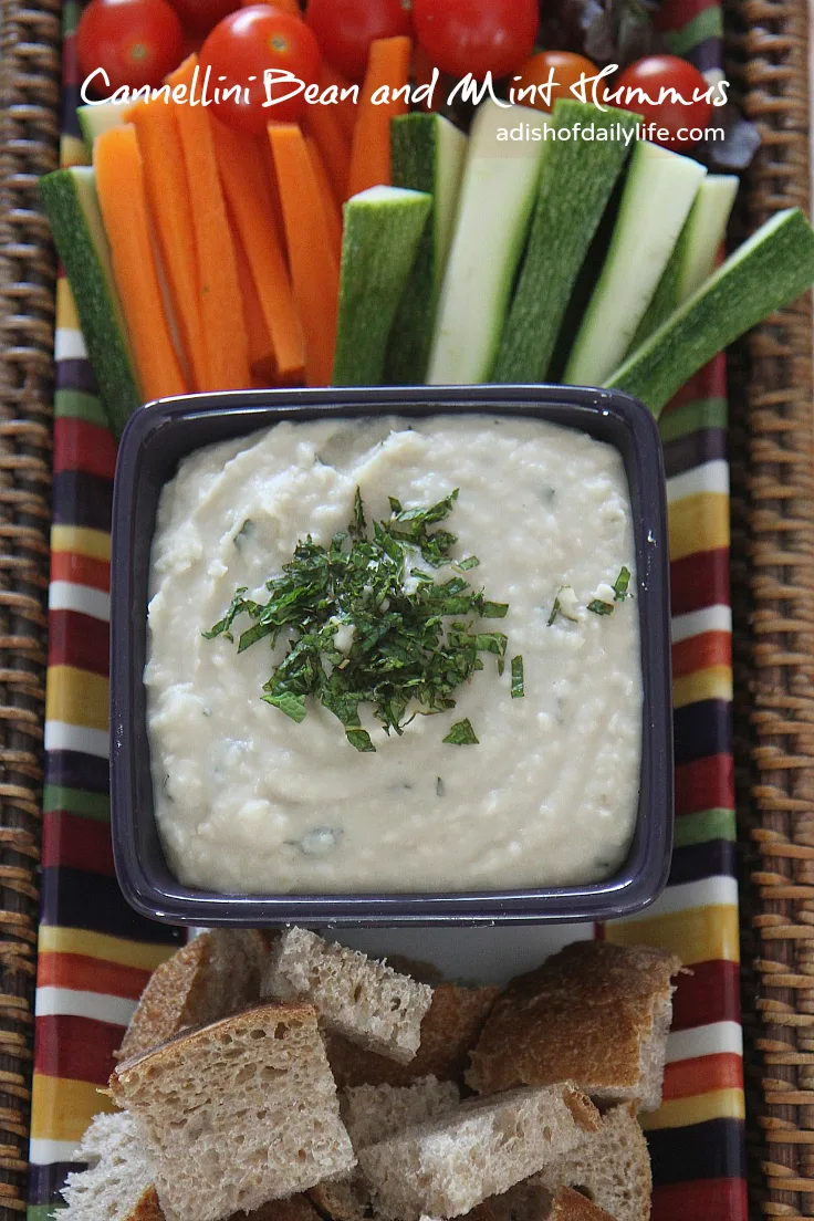 Cannellini Bean and Mint Hummus...an easy vegan appetizer dip recipe that takes minutes to make and will probably disappear in minutes too! If you're looking for something a bit healthier for tailgate season, this is it!