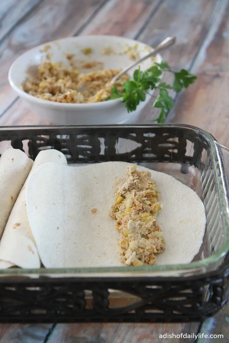 Filling the enchiladas with a chicken, cream cheese, corn, green chile and chipotle chili powder mixture