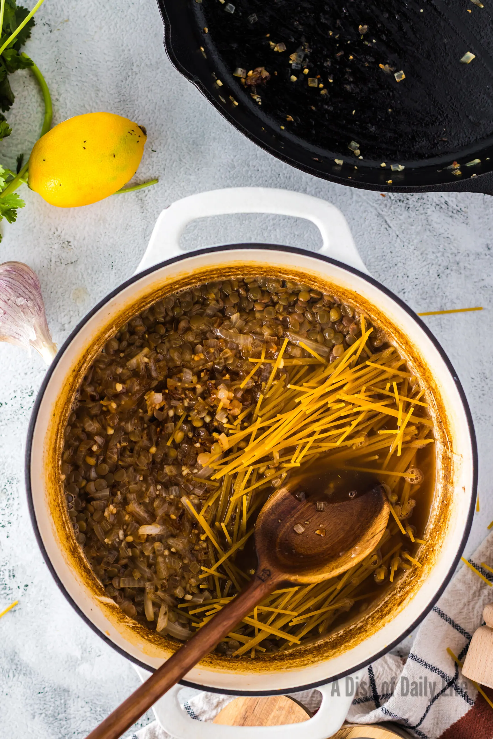 broken spaghetti added to lentil soup