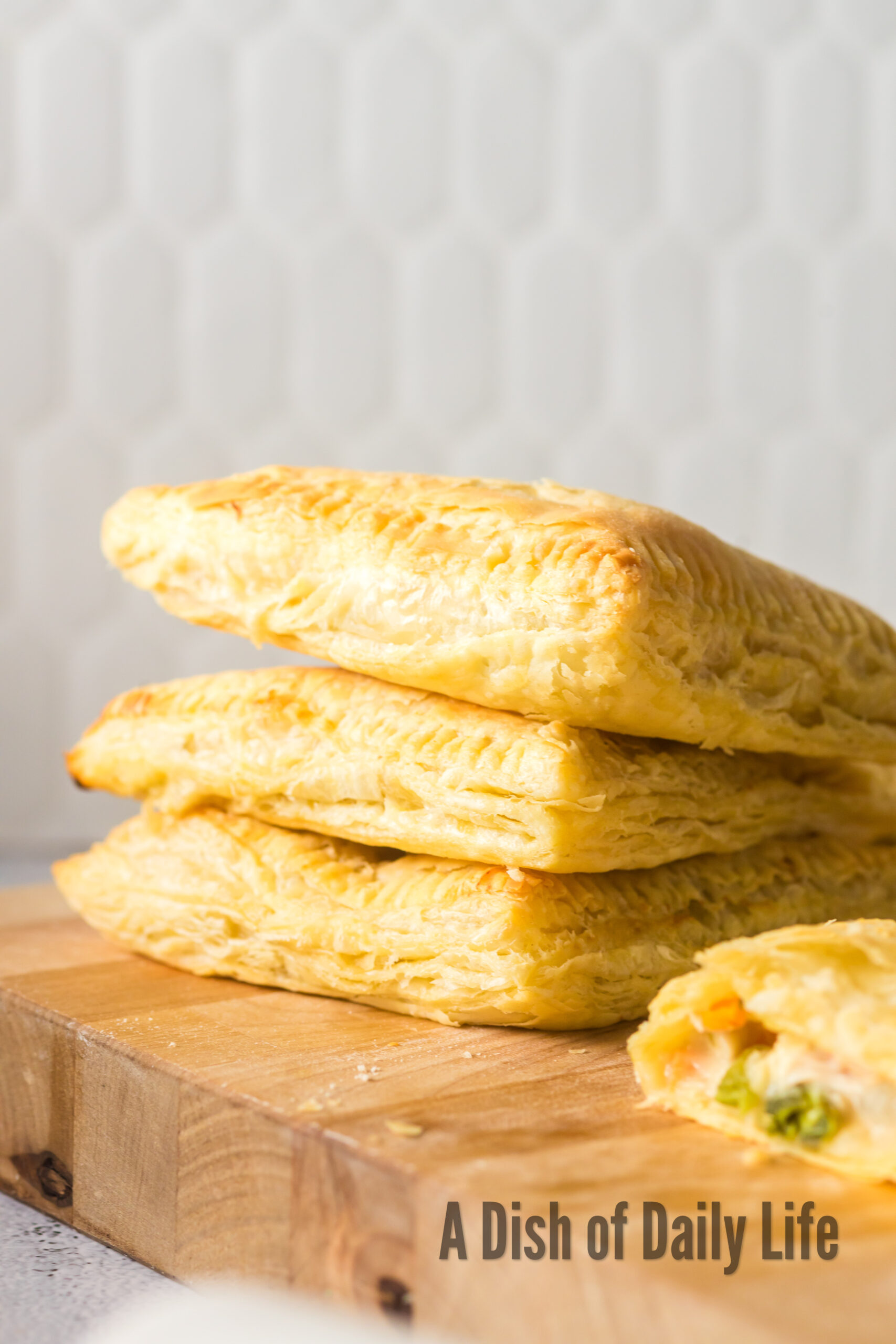 3 stacked puff pastry pot pies with a 4th cut in half to show filling.