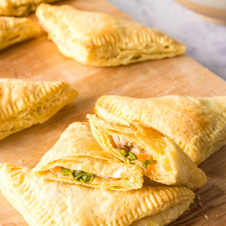 hand pies laid out on a cutting board with one cut in half to show filling