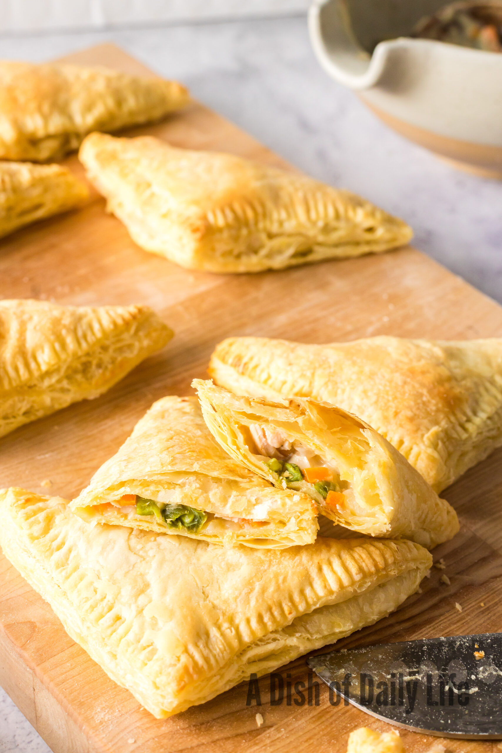 hand pies laid out on a cutting board with one cut in half to show filling