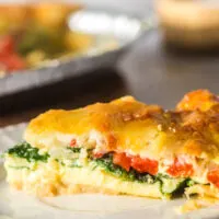 side view of a slice of quiche on a plate.