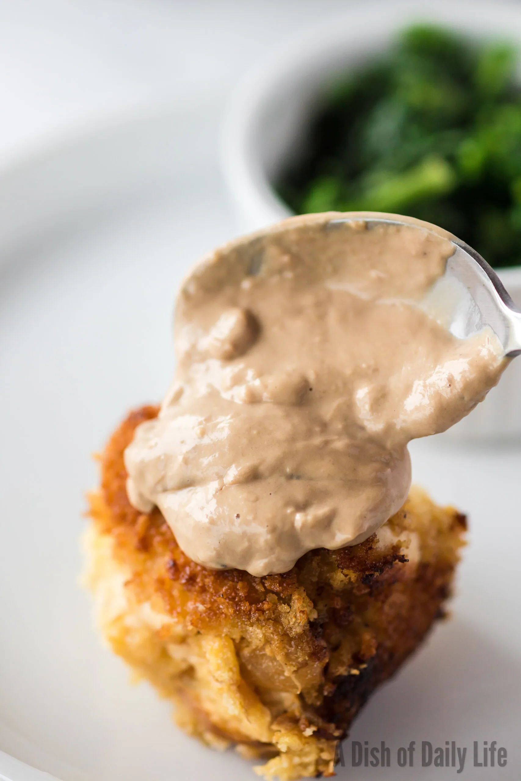 Goat Cheese Sauce being spooned over the top of a stuffed chicken