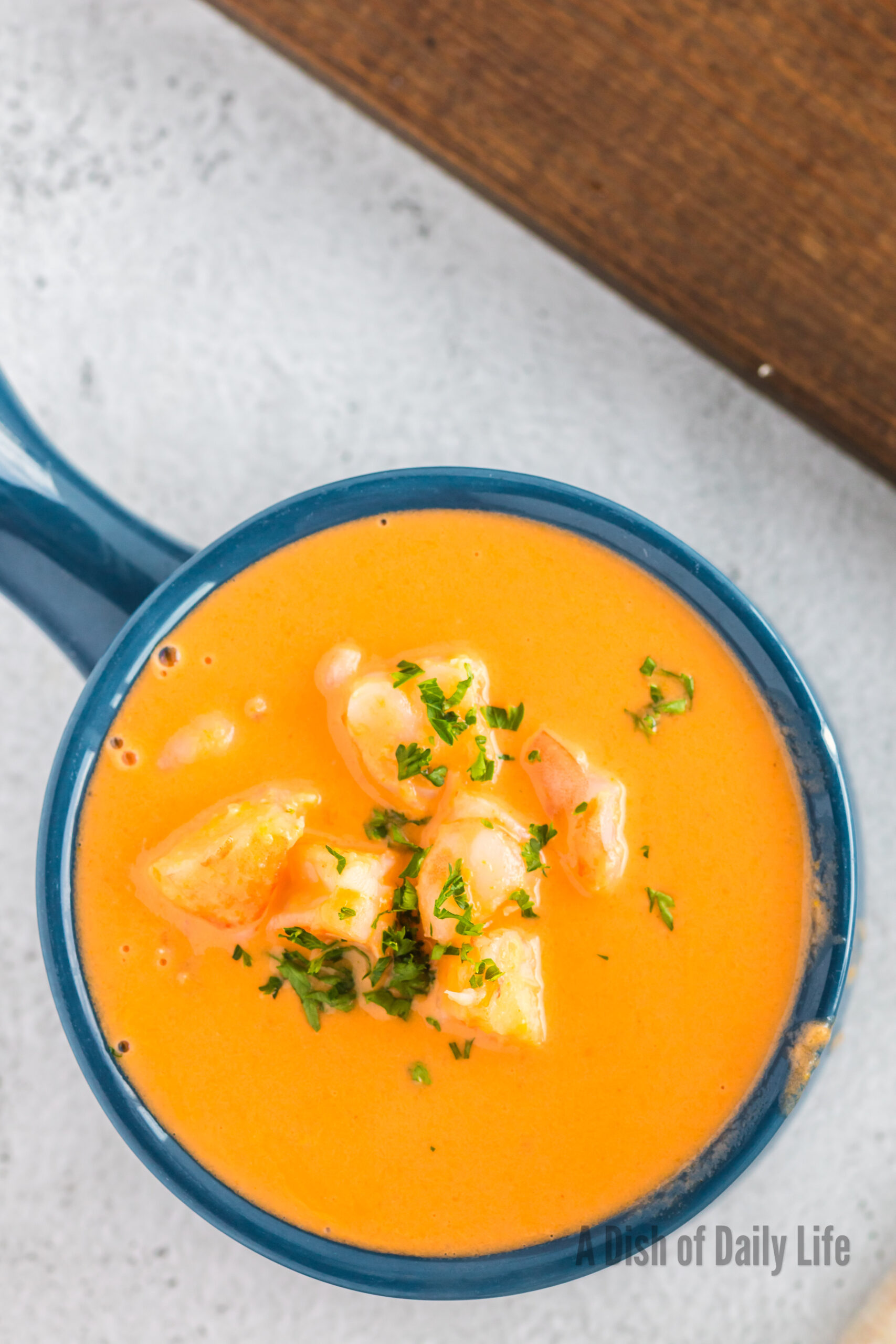 A bowl of seafood bisque topped with fresh parsley