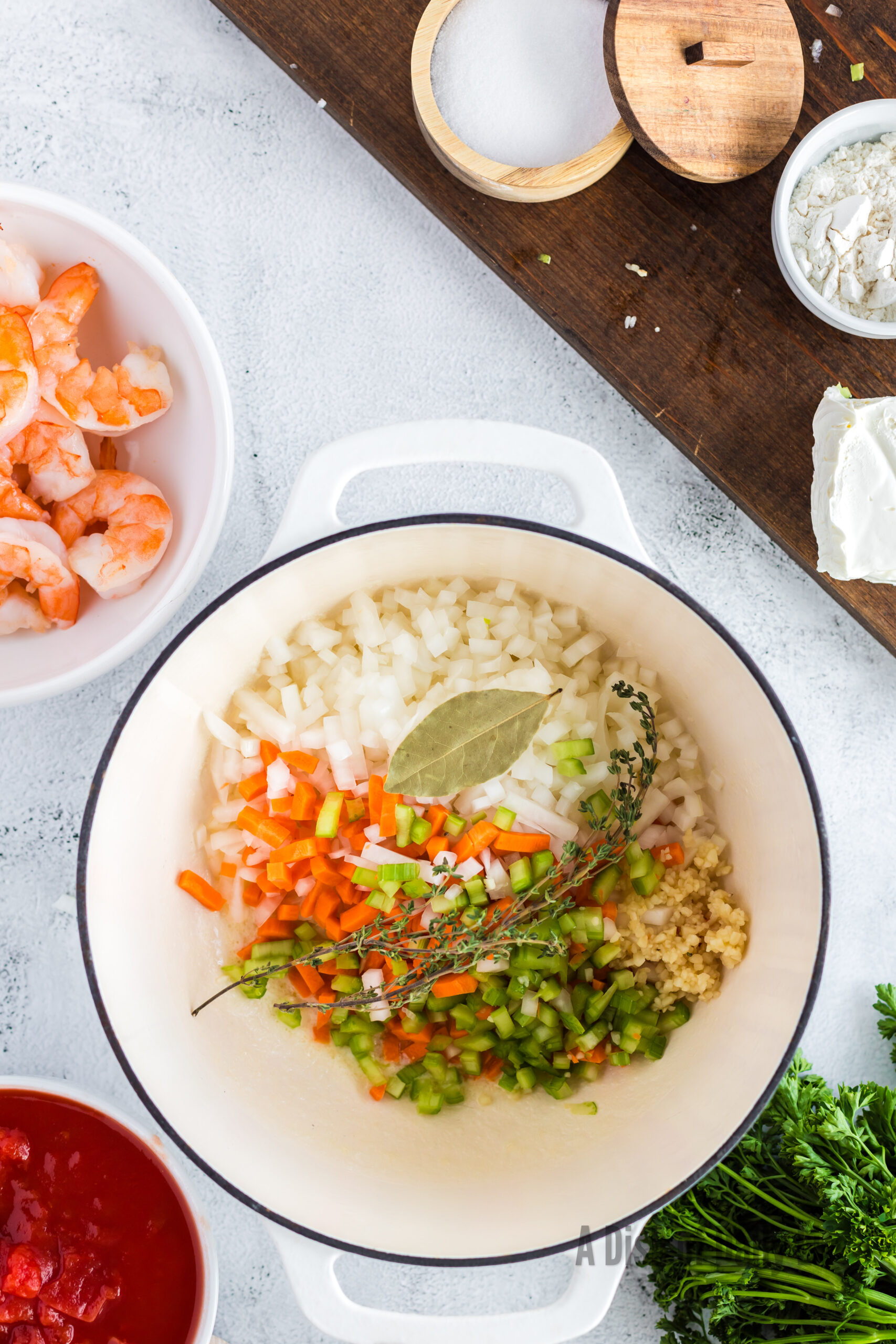 butter, onion, carrot, celery, garlic, bay leaf, and thyme all added to a soup pot.