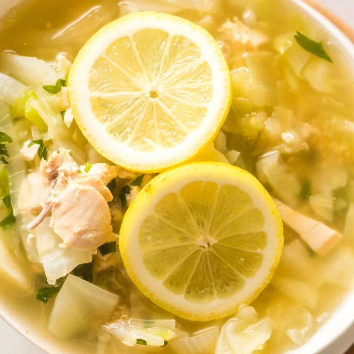 zoomed in image taken from the top looking down at bowl of soup with lemon slices.