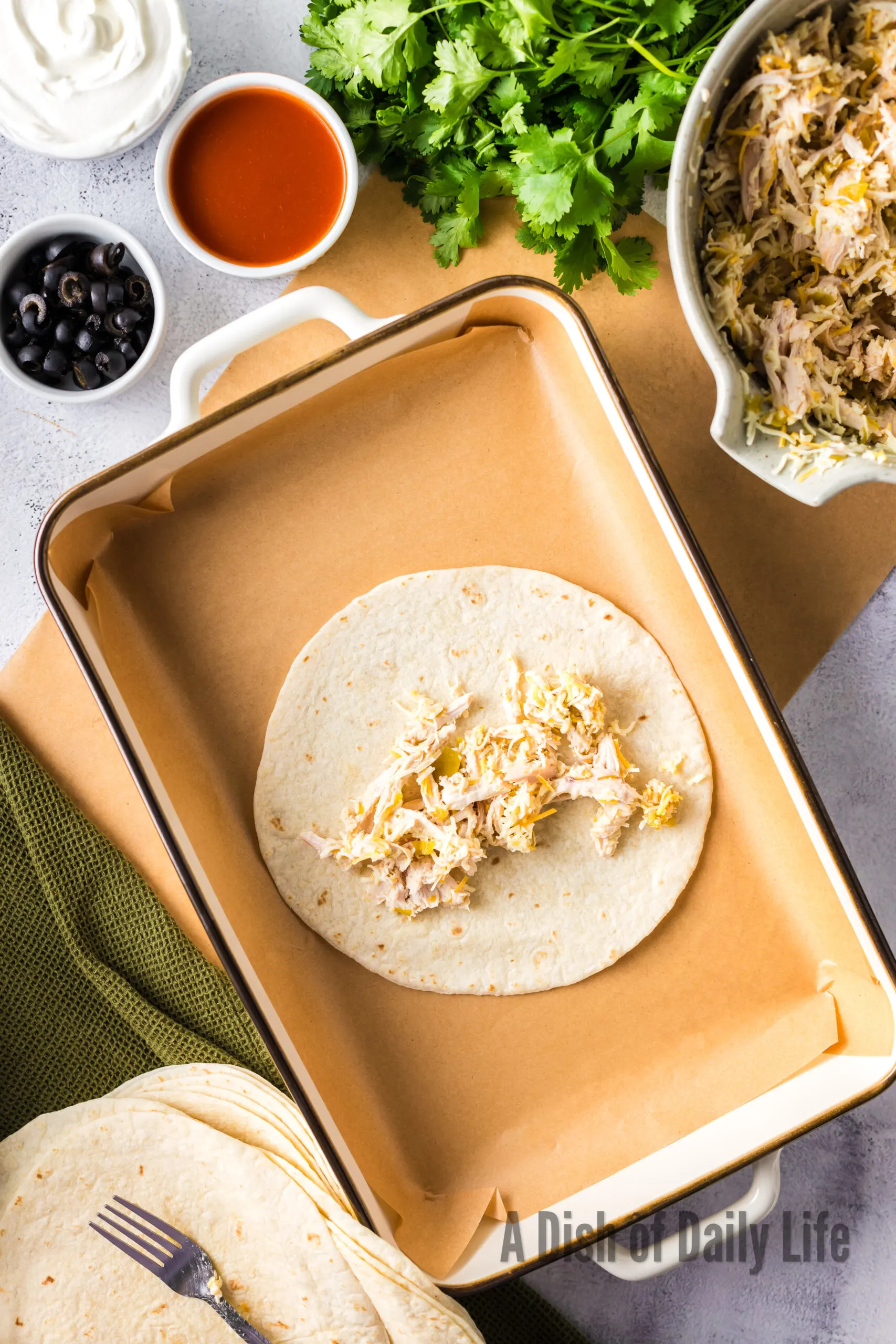 tortilla laid out with chicken mixture in the middle,