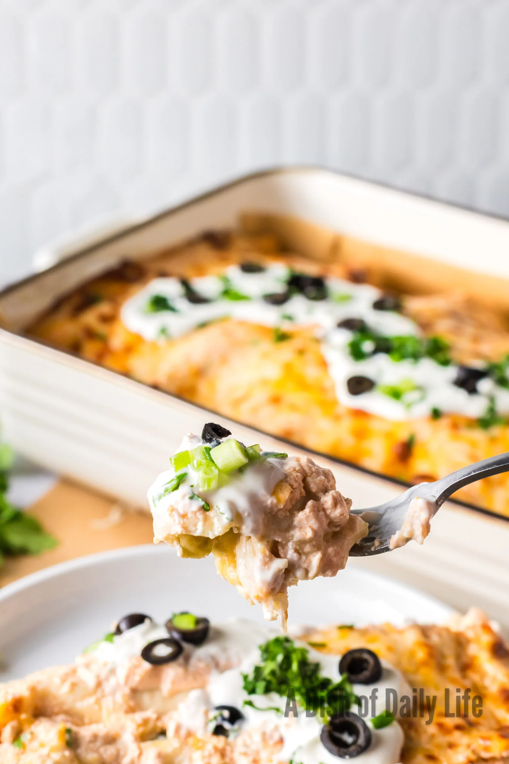 fork full of yummy enchiladas on plate.