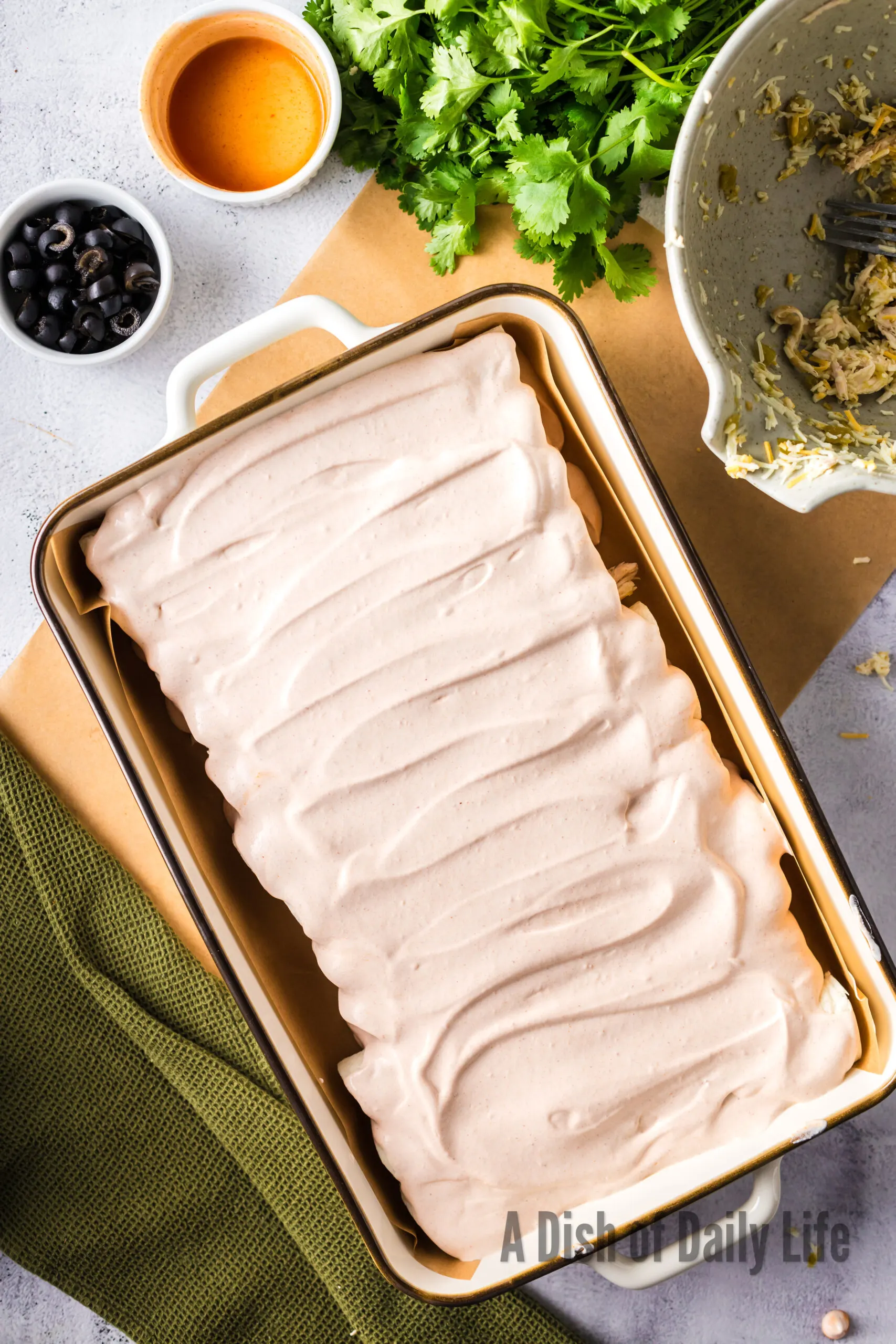 Sour cream enchilada sauce spread all over enchiladas