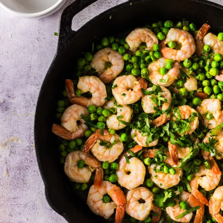 zoomed in image of cooked shrimp and peas,,.