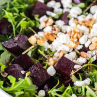 zoomed in image of beet salad in bowl with goat cheese