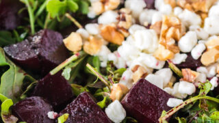 zoomed in image of beet salad in bowl with goat cheese