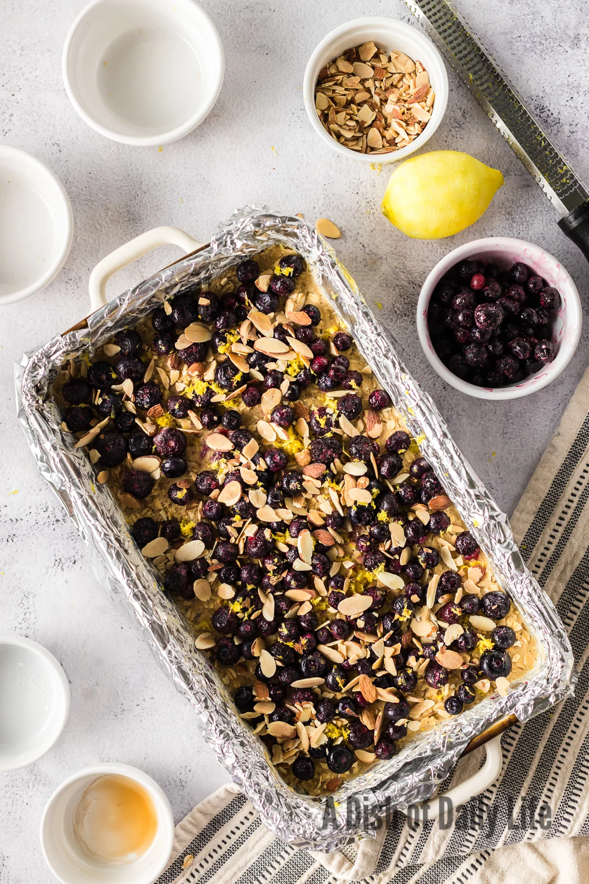 lemon zest, almonds and blueberries laid out over crust