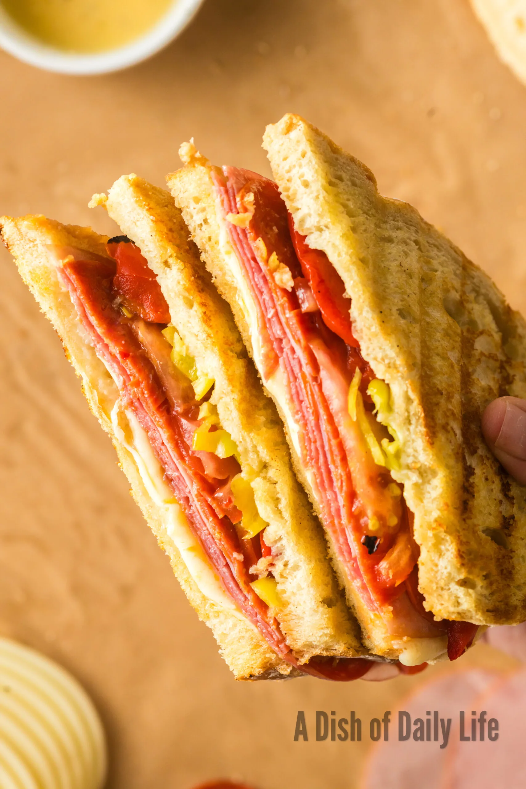 hand holding cut pepperoni panini to show yummy fillings