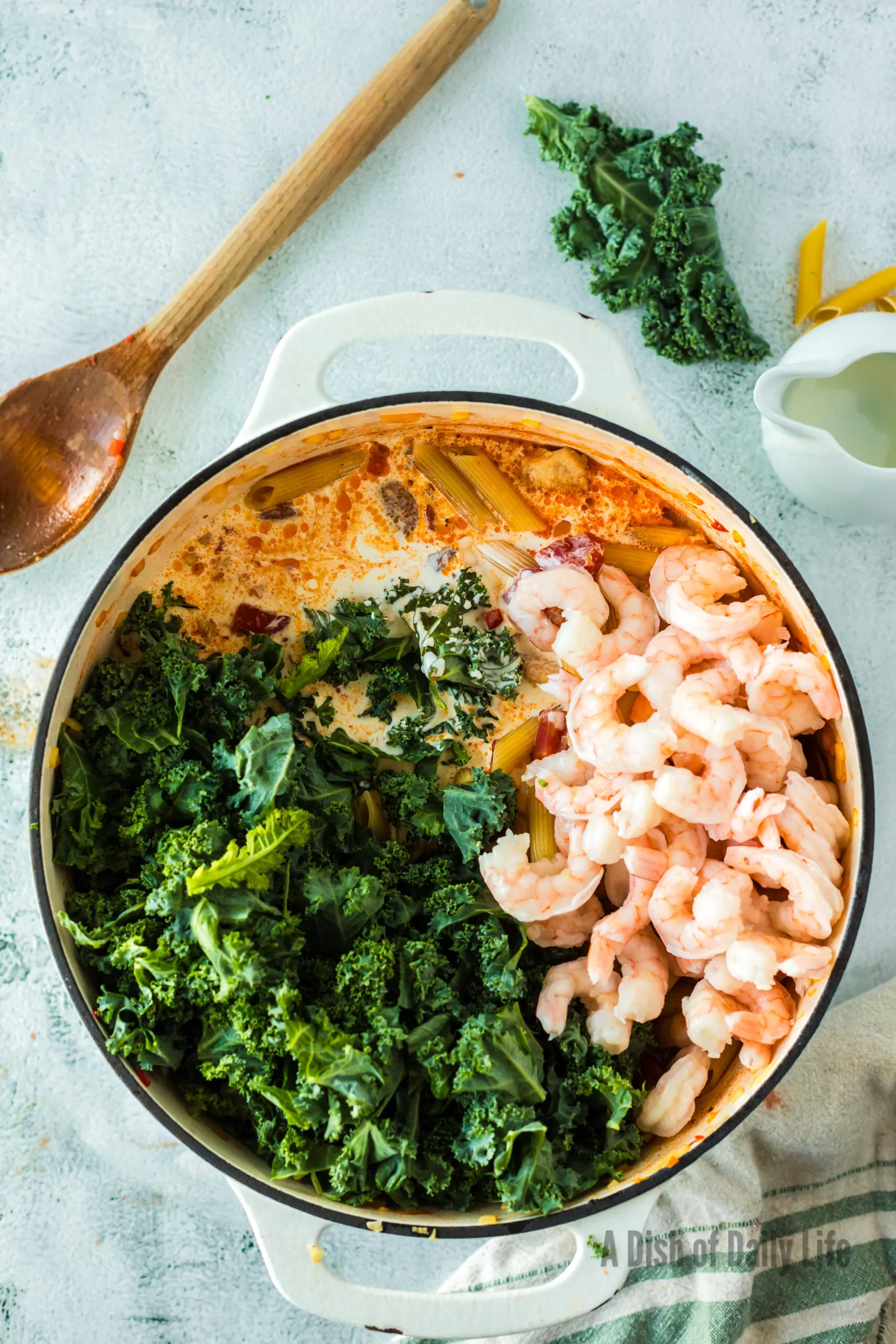 Kale, shrimp and cream added to dutch oven