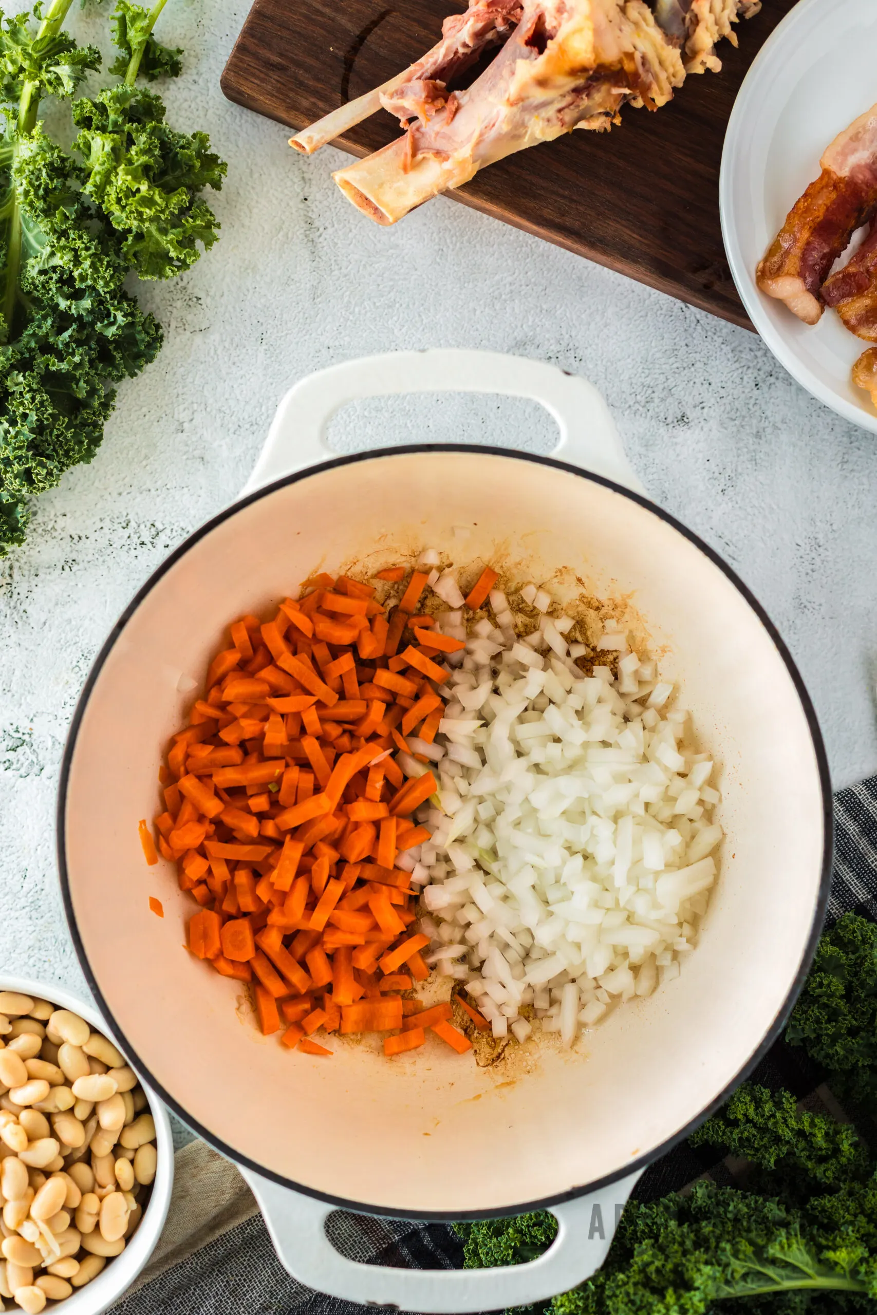 Onions and Carrots added to bacon fat in a dutch oven.
