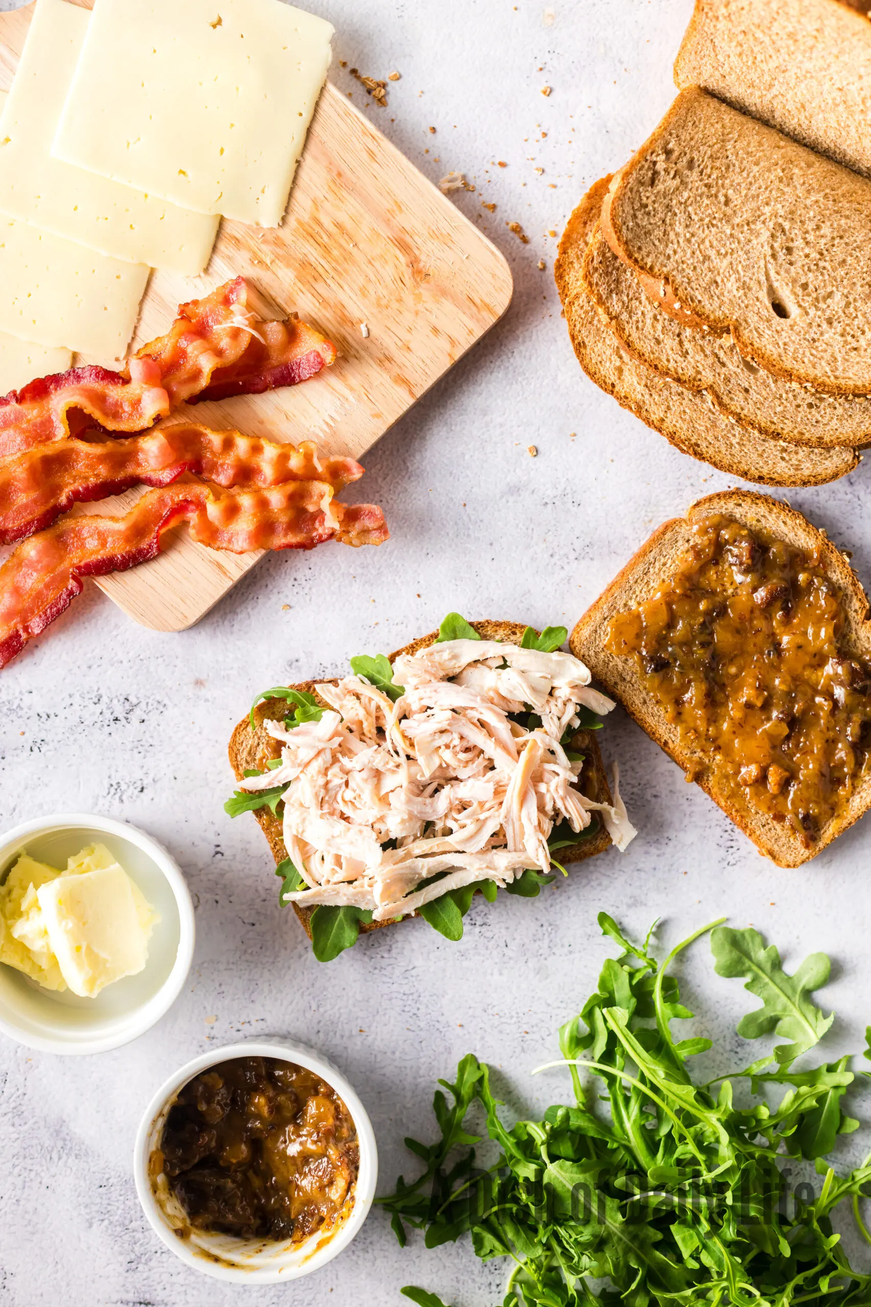 shredded turkey on top of arugula on bread