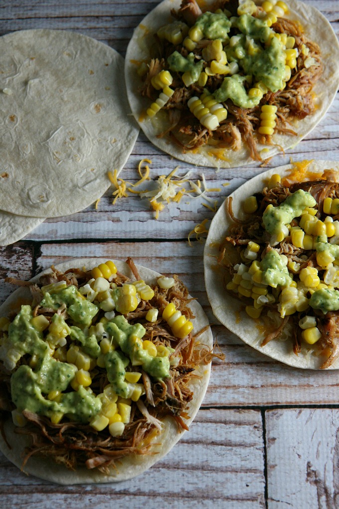 Pulled Pork Quesadillas...pulled pork, sweet corn, and melted cheese layered between flour tortillas, and topped with a tangy tomatillo guacamole...a delicious alternative for Mexican night!