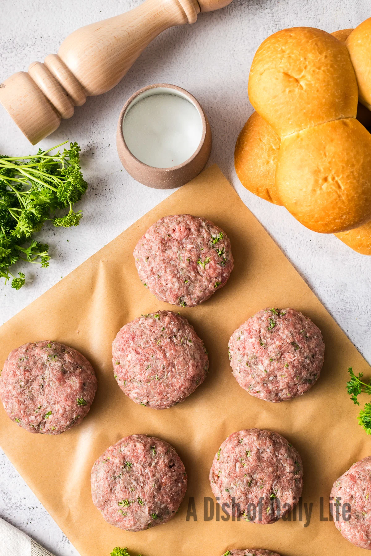6 burger patties pressed and laid out on counter.
