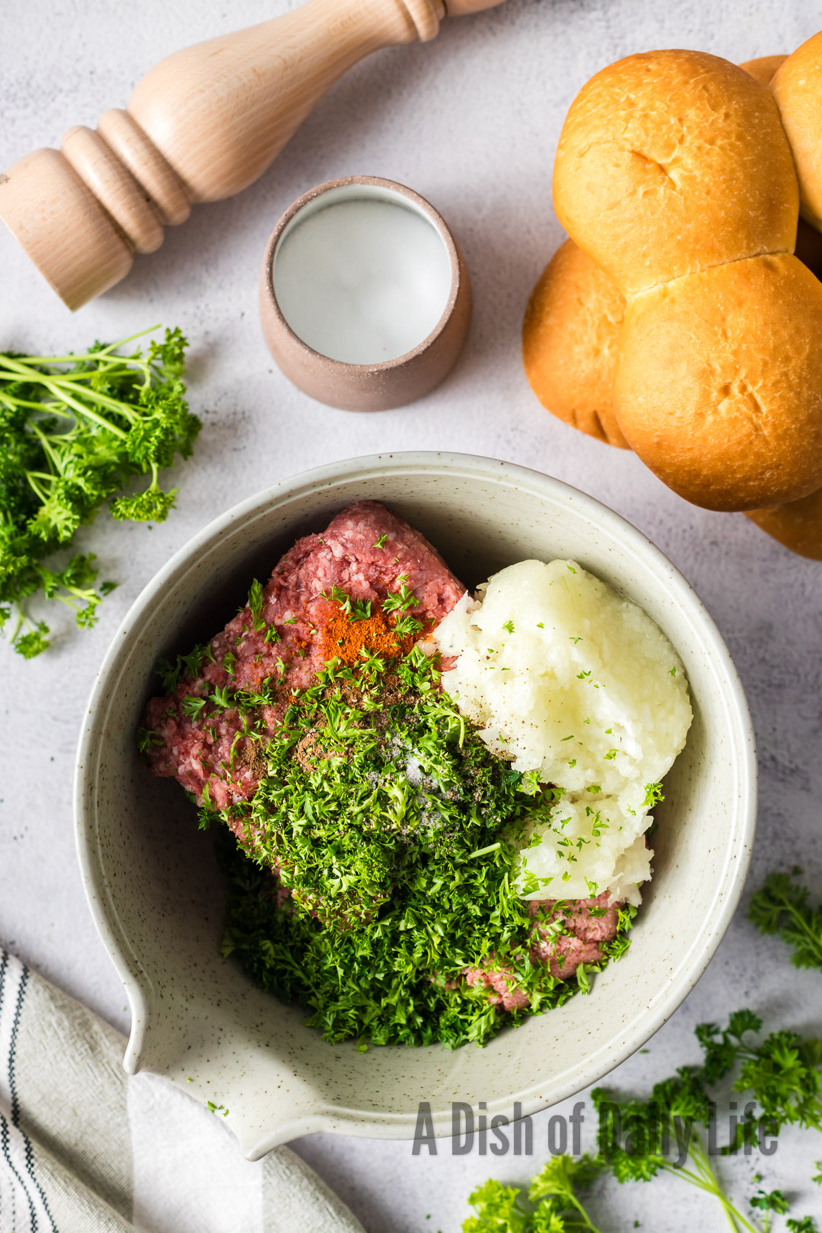 ground lamb, ground beef, onion, parsley, allspice, salt, pepper and cayenne added to a bowl, unmixed