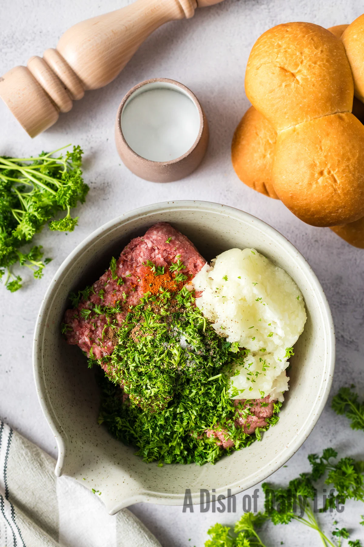 ground lamb, ground beef, onion, parsley, allspice, salt, pepper and cayenne added to a bowl, unmixed