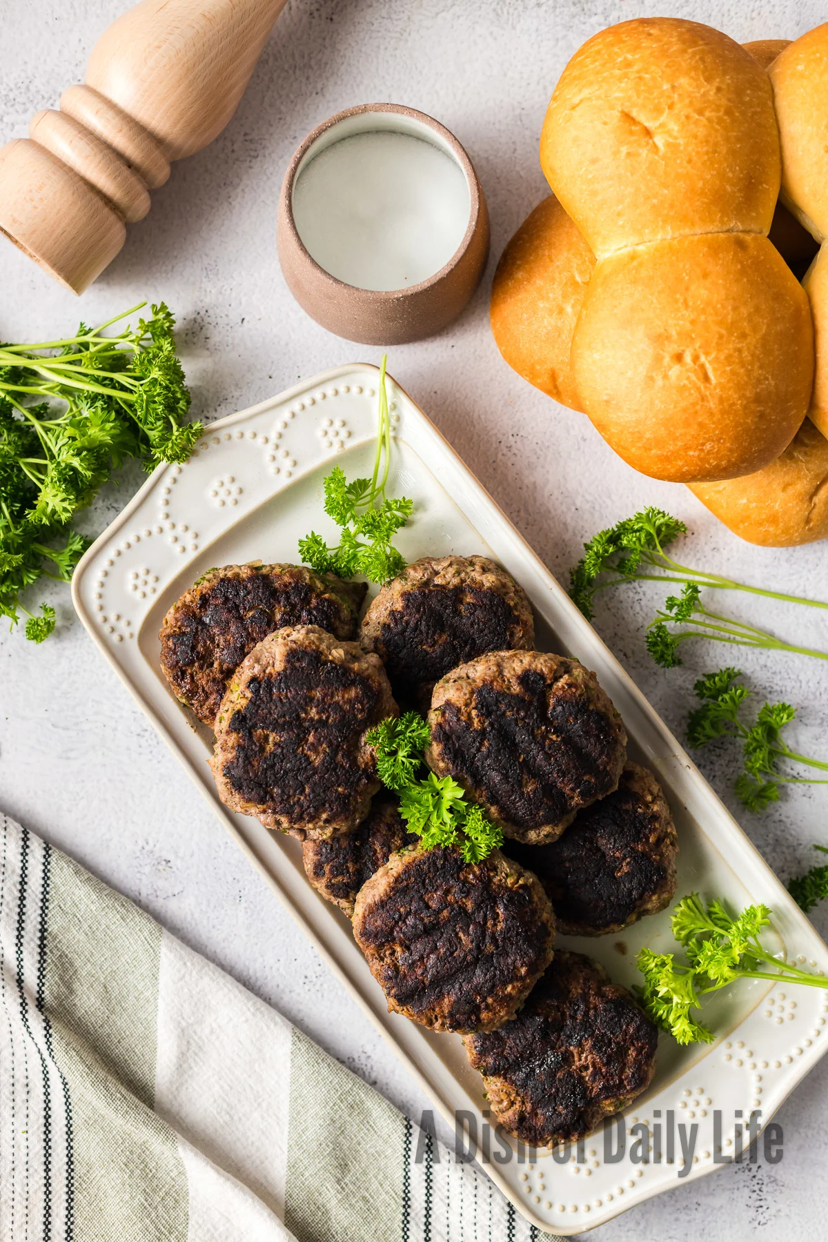 Grilled and cooked burger patties on platter