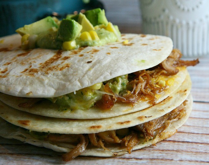 Pulled Pork Quesadillas...pulled pork, sweet corn, and melted cheese layered between flour tortillas, and topped with a tangy tomatillo guacamole...a delicious alternative for Mexican night!