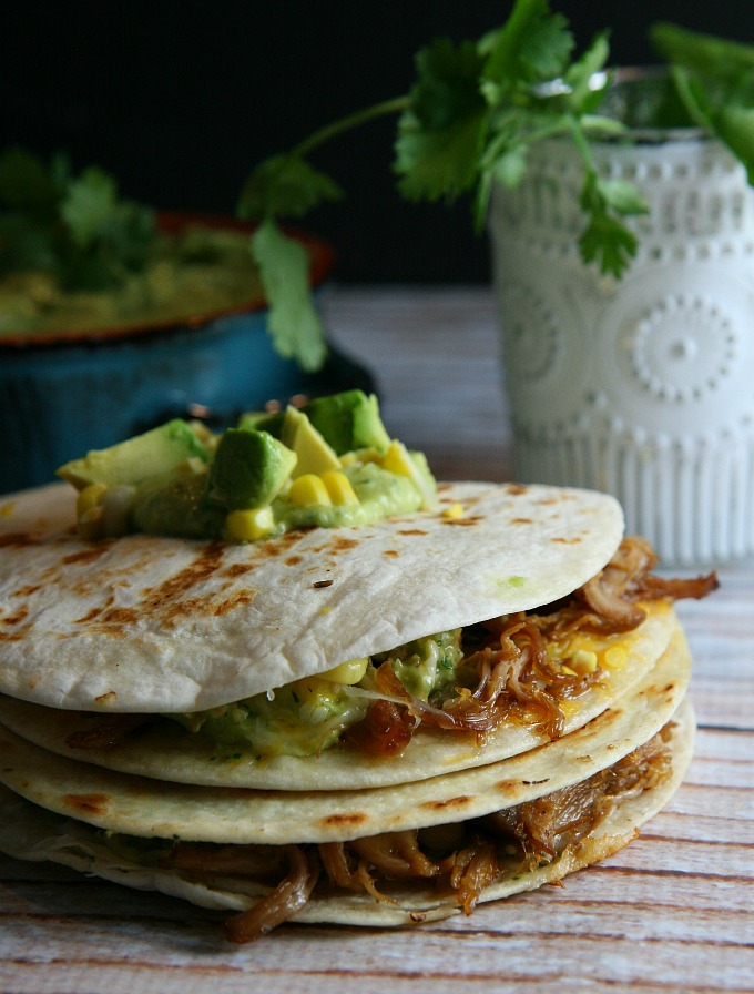 Pulled Pork Quesadillas...pulled pork, sweet corn, and melted cheese layered between flour tortillas, and topped with a tangy tomatillo guacamole...a delicious alternative for Mexican night! 