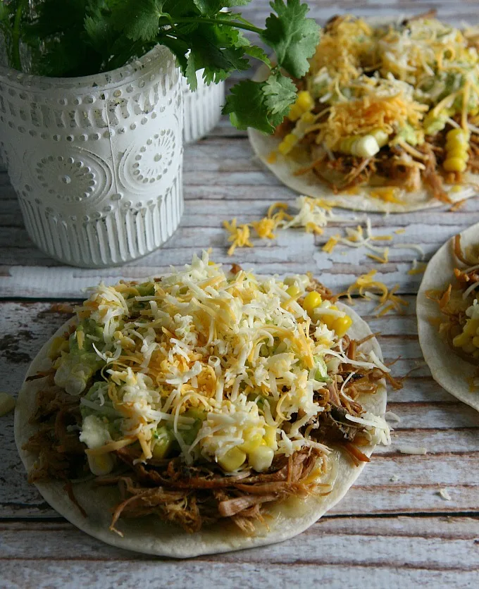 Pulled Pork Quesadillas...pulled pork, sweet corn, and melted cheese layered between flour tortillas, and topped with a tangy tomatillo guacamole...a delicious alternative for Mexican night!