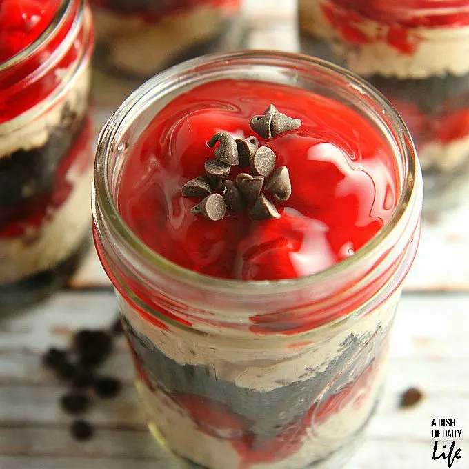 No need to heat the kitchen up! These No Bake Cherry Chocolate Cheesecake Parfaits are the perfect dessert recipe for barbeques or dinner parties, and they're easily transported in individual serving mason jars! 