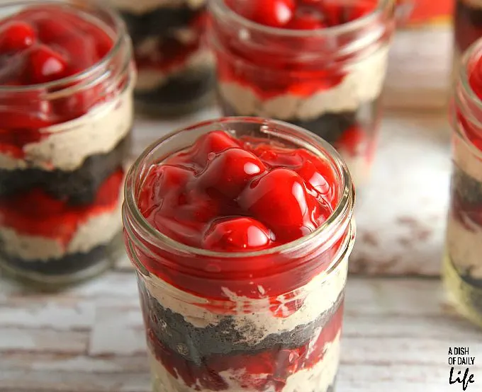 No need to heat the kitchen up! These No Bake Cherry Chocolate Cheesecake Parfaits are the perfect dessert recipe for barbeques or dinner parties, and they're easily transported in individual serving mason jars! 