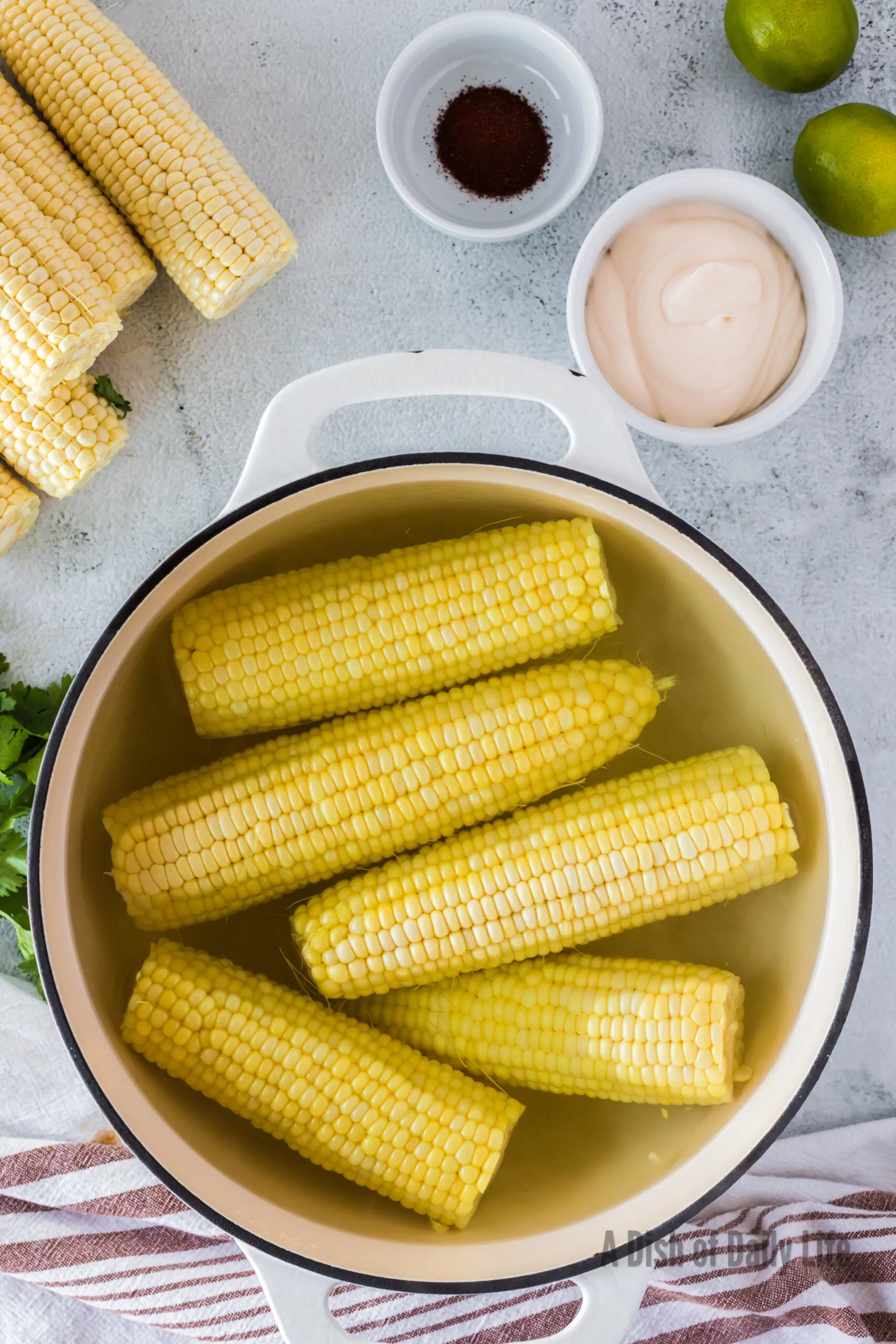 Ears of corn cooking in a large pot of water.