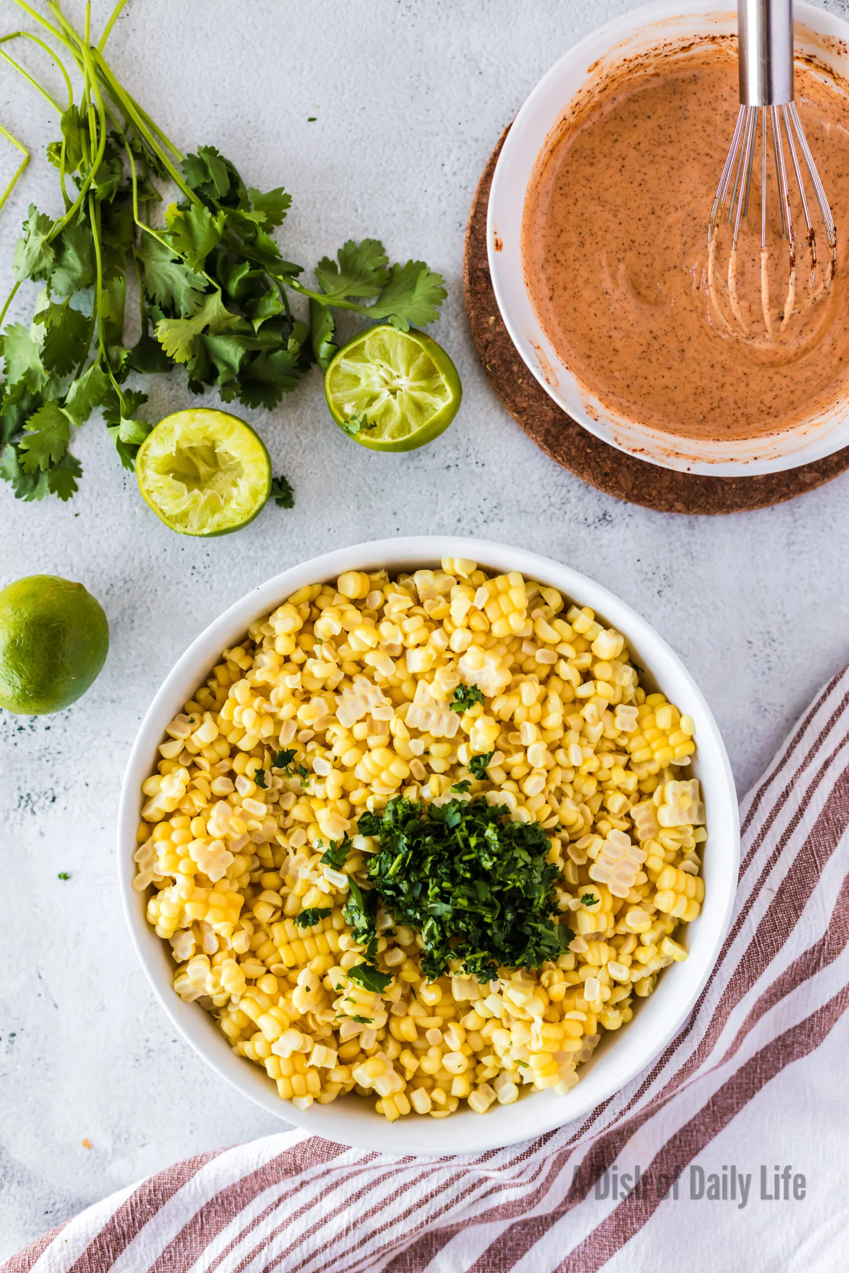 Shucked corn and cilantro in a large mixing bowl.
