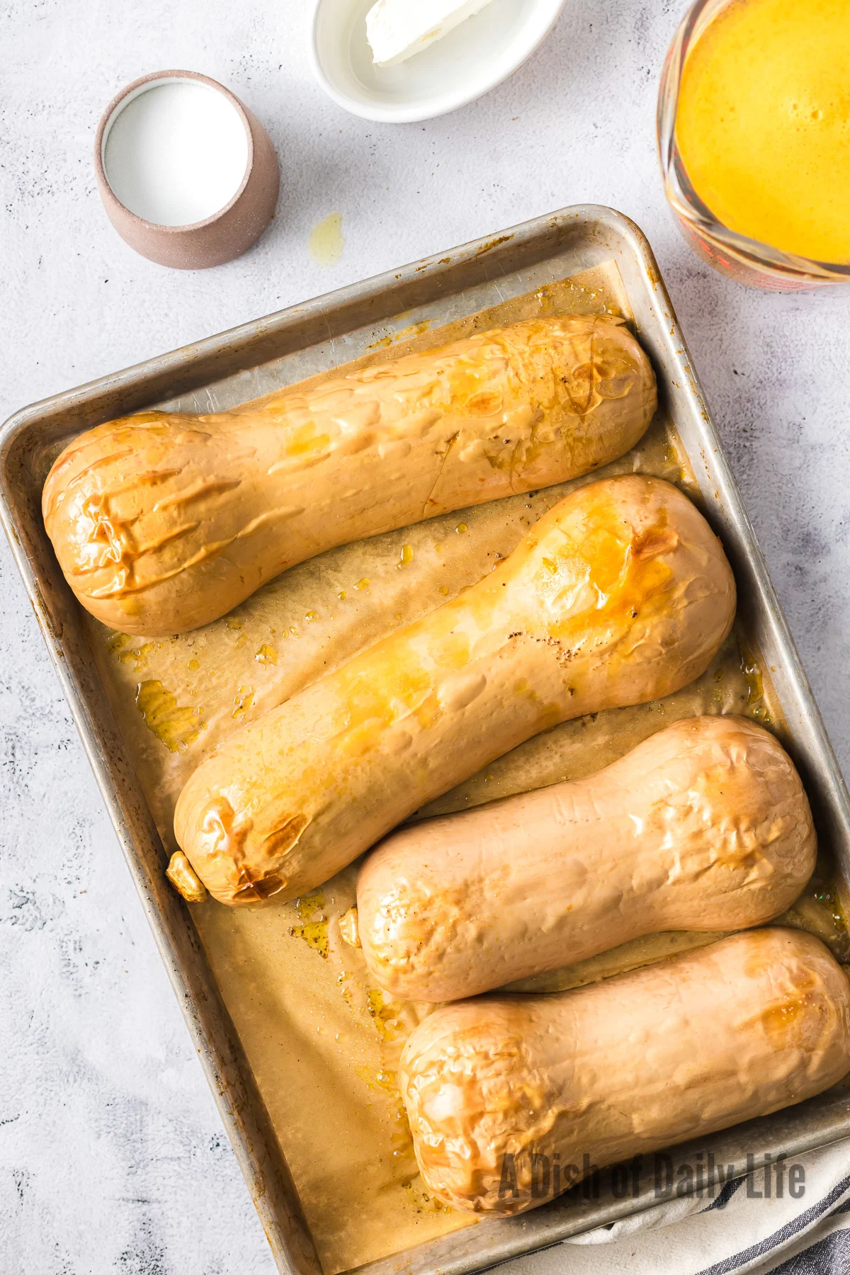 Roasted butternut squash on baking sheet facedown.