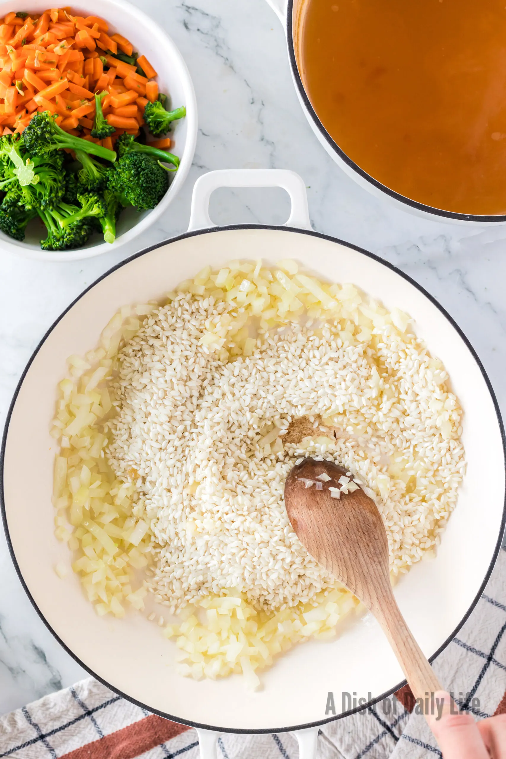 Sauteed onion in pan with rice added.