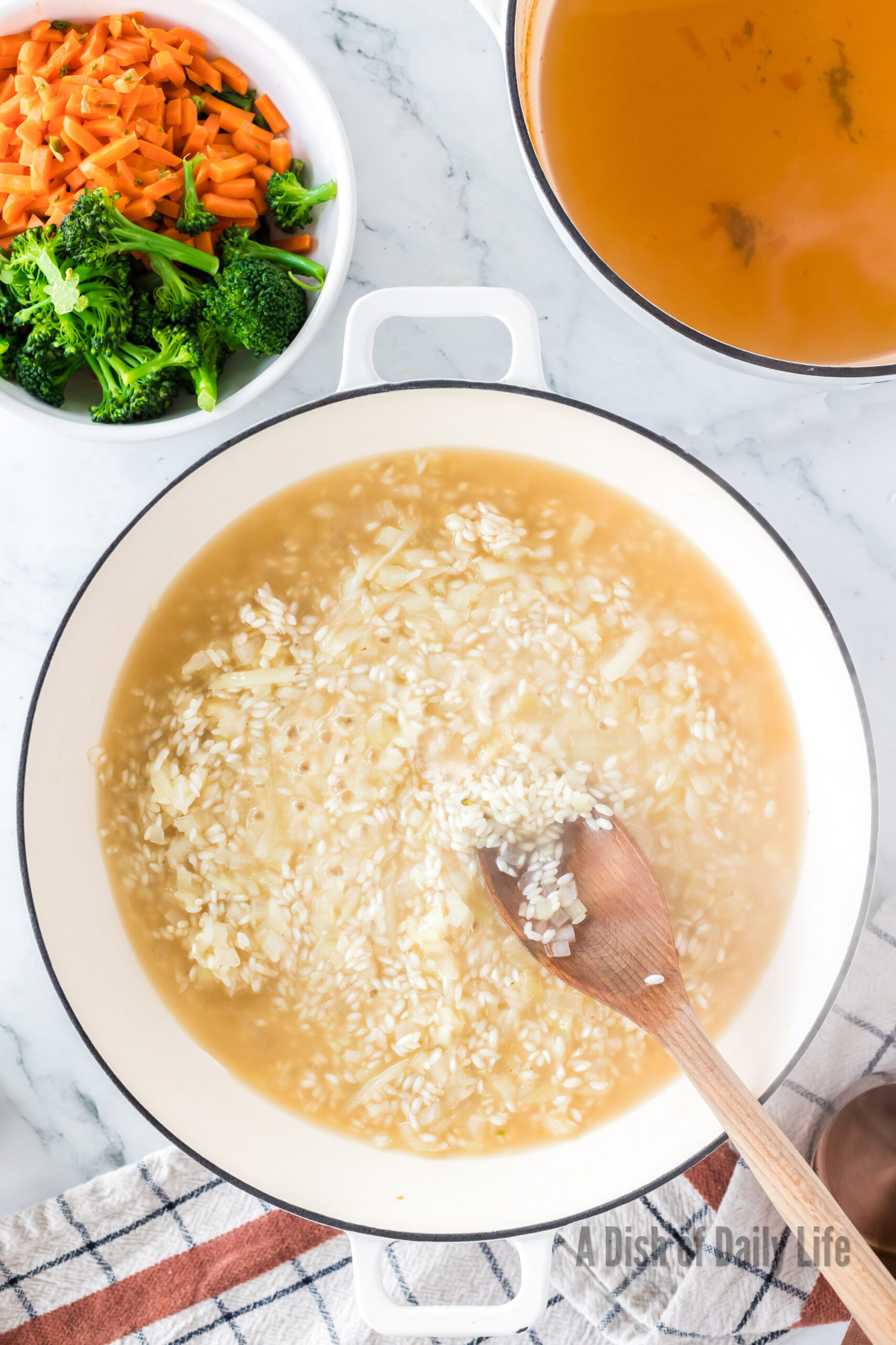 Vegetable broth added to rice and onion mixture.