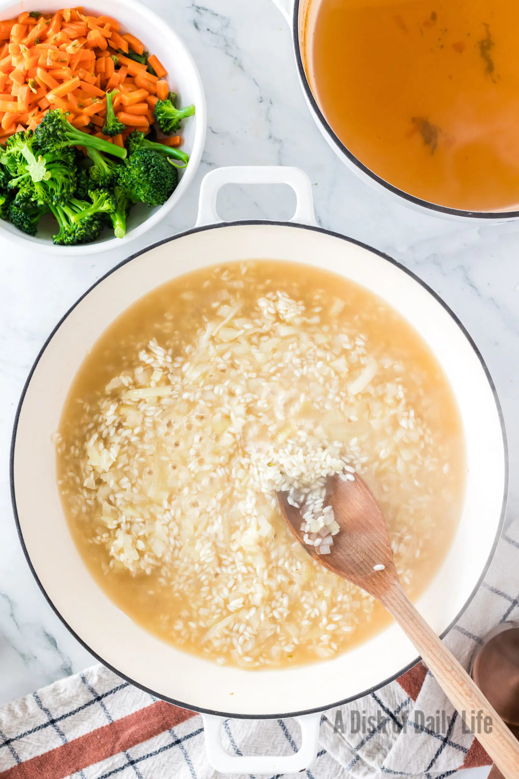 Vegetable broth added to rice and onion mixture.