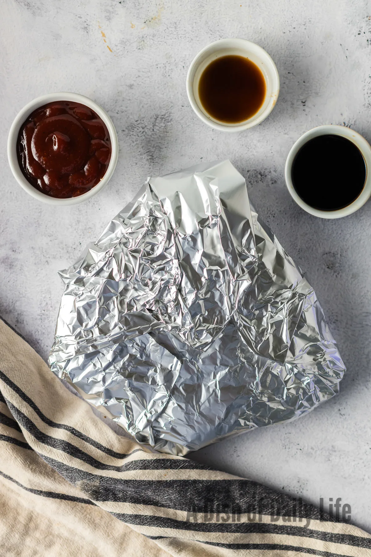 seasoned and flavored brisket wrapped up on tin foil.