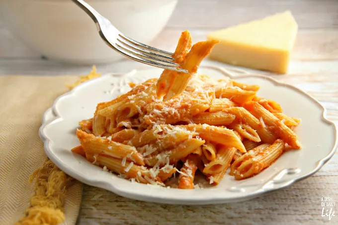 This Lightened Up Pink Vodka Sauce recipe, served over pasta, is a delicious easy meal when you need to get dinner on the table fast! It makes enough sauce for two pounds of pasta, so freeze your leftover sauce for another night. Created for Cooking for a Cure to bring awareness to Breast Cancer Awareness Month. Vegetarian