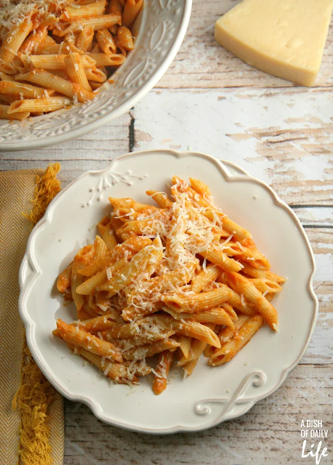 This Lightened Up Pink Vodka Sauce recipe, served over pasta, is a delicious easy meal when you need to get dinner on the table fast! It makes enough sauce for two pounds of pasta, so freeze your leftover sauce for another night. Created for Cooking for a Cure to bring awareness to Breast Cancer Awareness Month. Vegetarian