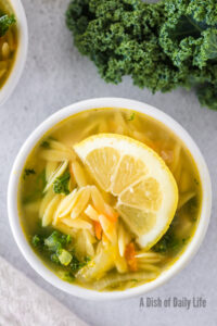 Zoomed in image of bowl of lemon chicken orzo soup