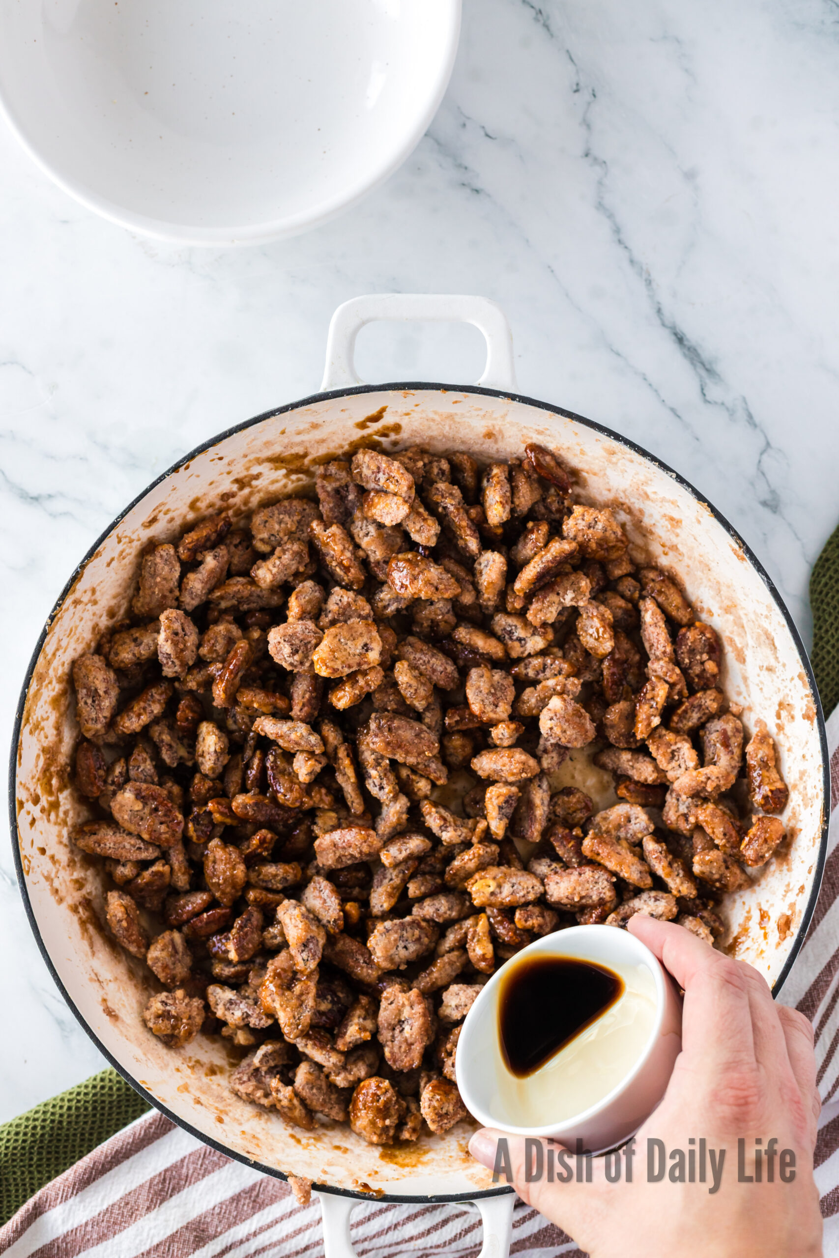 vanilla being added to cinnamon pecans