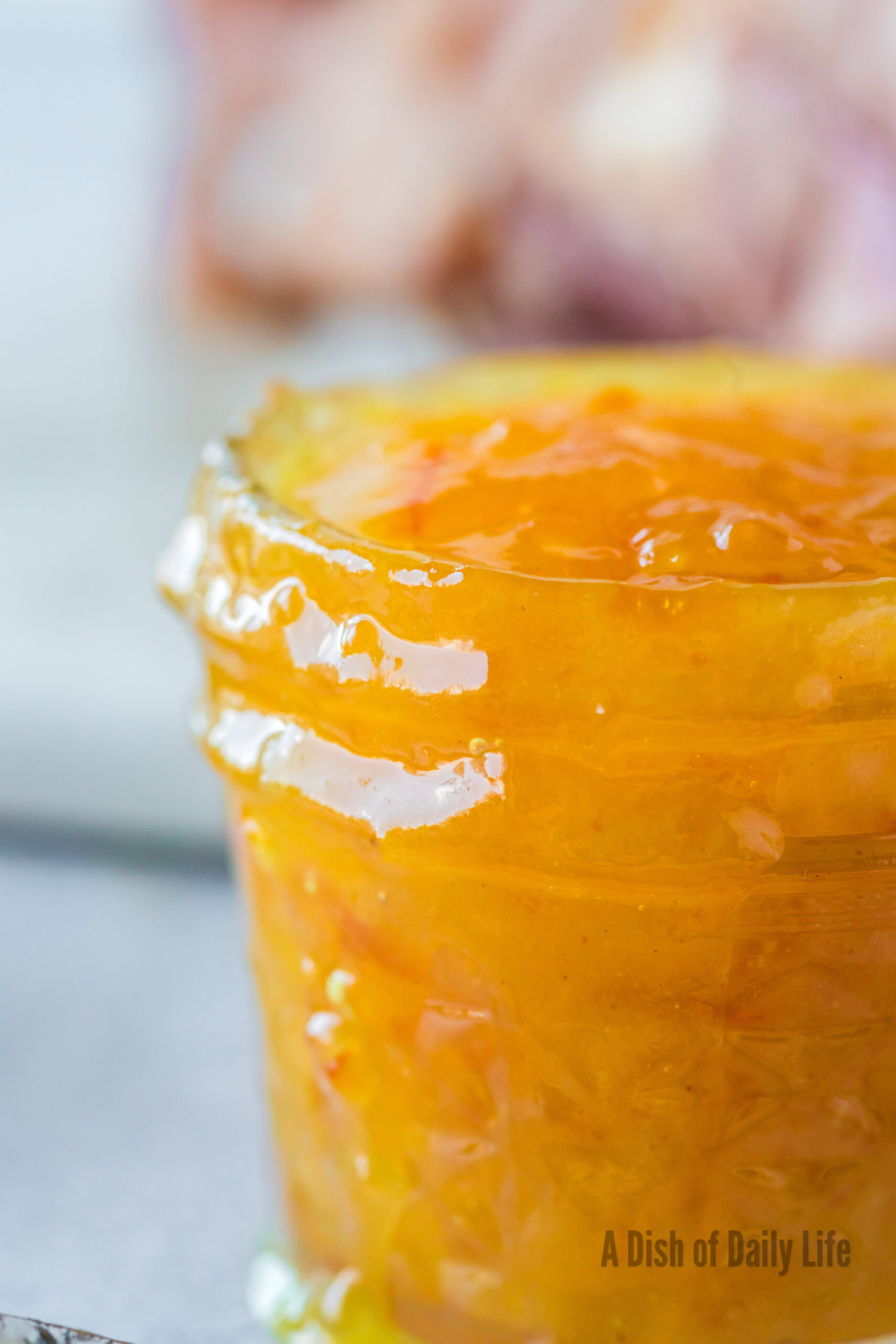 Zoomed in image of orange marmalade glaze in jar
