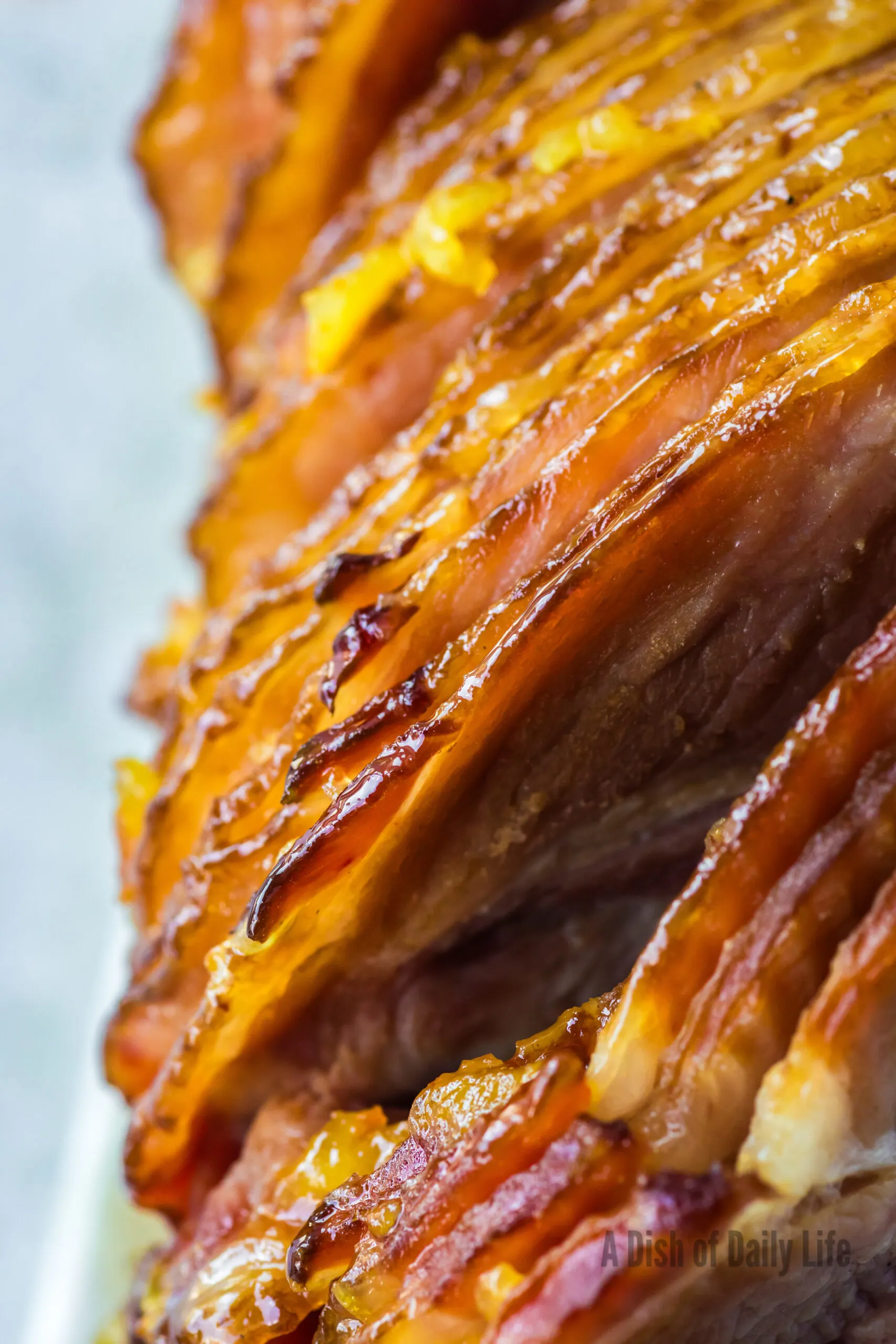 zoome din image of sliced ham cooked and covered in orange glaze