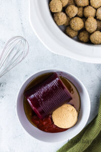 sriarcha, cranberry sauce, brown sugar and honey all placed in a bowl, unmixed.