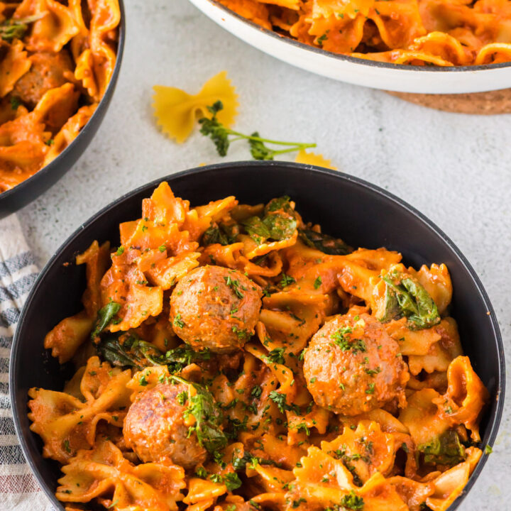 bowl full of pasta and meatballs, ready to eat